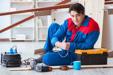 Genç marangoz ahşap kalaslarla çalışmaya ara veriyor.