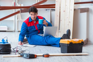 Dizüstü bilgisayarı olan genç bir marangoz