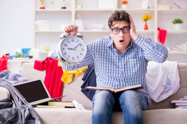 Genç adam dağınık bir odada çalışıyor.