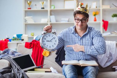 Genç adam dağınık bir odada çalışıyor.