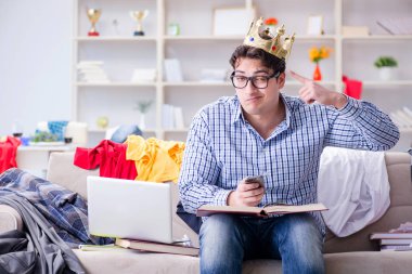 Genç adam dağınık bir odada çalışıyor.