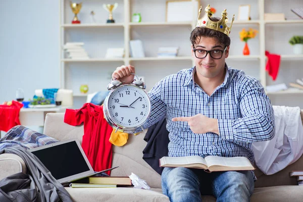 Genç adam dağınık bir odada çalışıyor.