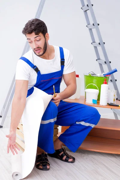 Tamirci, duvar kağıdıyla evde tadilat yapıyor.