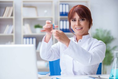 Bir laboratuarda deney yapan kadın bir bilim adamı.