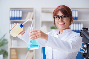 Bir laboratuarda deney yapan kadın bir bilim adamı.