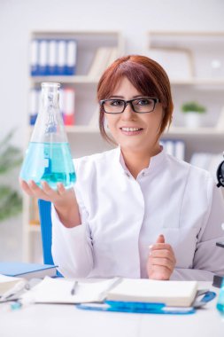 Bir laboratuarda deney yapan kadın bir bilim adamı.