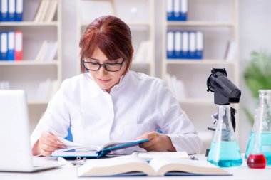 Bir laboratuarda deney yapan kadın bir bilim adamı.