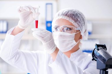 Bir laboratuarda deney yapan kadın bir bilim adamı.