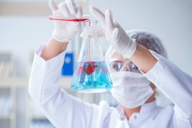 Bir laboratuarda deney yapan kadın bir bilim adamı.