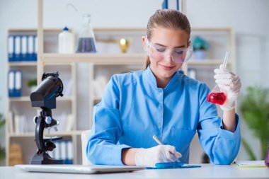 Bir laboratuarda deney yapan kadın bir bilim adamı.