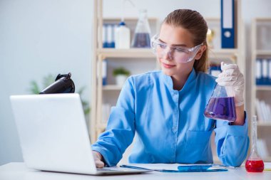 Bir laboratuarda deney yapan kadın bir bilim adamı.