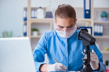 Bir laboratuarda deney yapan kadın bir bilim adamı.