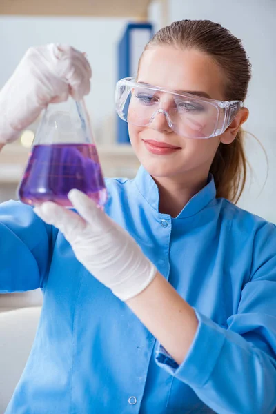 Bir laboratuarda deney yapan kadın bir bilim adamı.