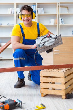 Tamirci marangoz. Dolaşım halindeki tahta testereyi kesiyor.