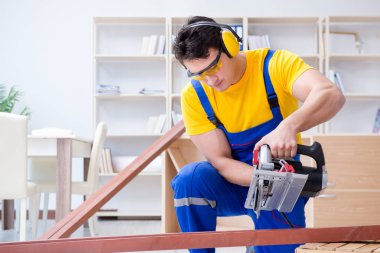 Tamirci marangoz. Dolaşım halindeki tahta testereyi kesiyor.