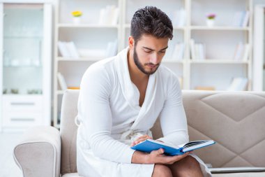 Öğrenci işadamı genç adam bir kitap okuyor.