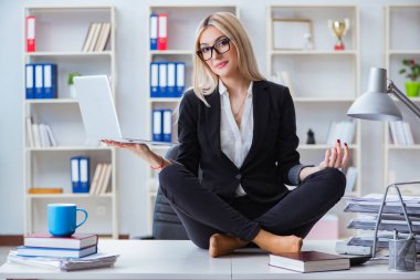 İş kadını ofiste meditasyon yaparken hayal kırıklığına uğradı