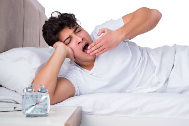 Yatakta uykusuzluk çeken bir adam.