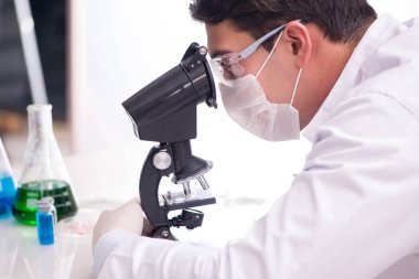 Laboratuvarda virüs aşısı üzerinde çalışan erkek doktor.