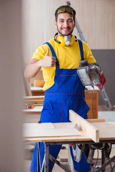 Joven carpintero reparador trabajando con herramientas eléctricas poli eléctrica — Foto de Stock