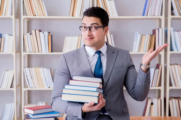 Étudiant en droit des affaires avec pile de livres travaillant en bibliothèque — Photo