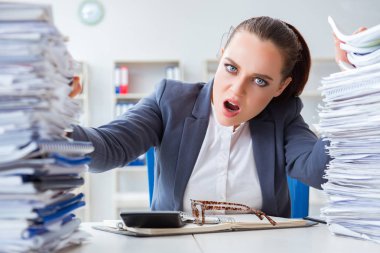 Evrak işleriyle uğraşan yorgun bir iş kadını.