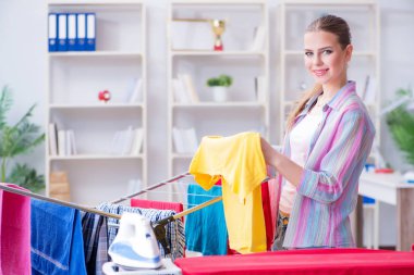 Genç ev hanımı evde çamaşır yıkıyor.