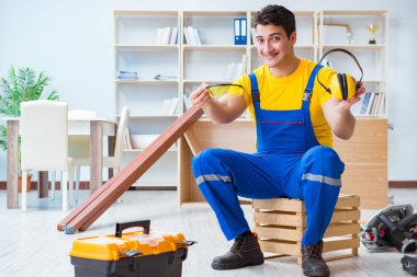 Tamirci marangoz tahta kalaslarla çalışıyor.