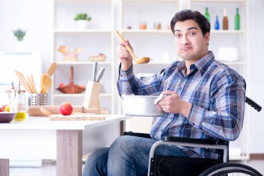 Engelli adam mutfakta çorba hazırlıyor.