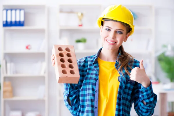 Mujer con ladrillo en concepto de construcción — Foto de Stock