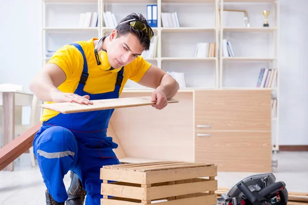 Tamirci marangoz ahşap tahtayı inceliyor.