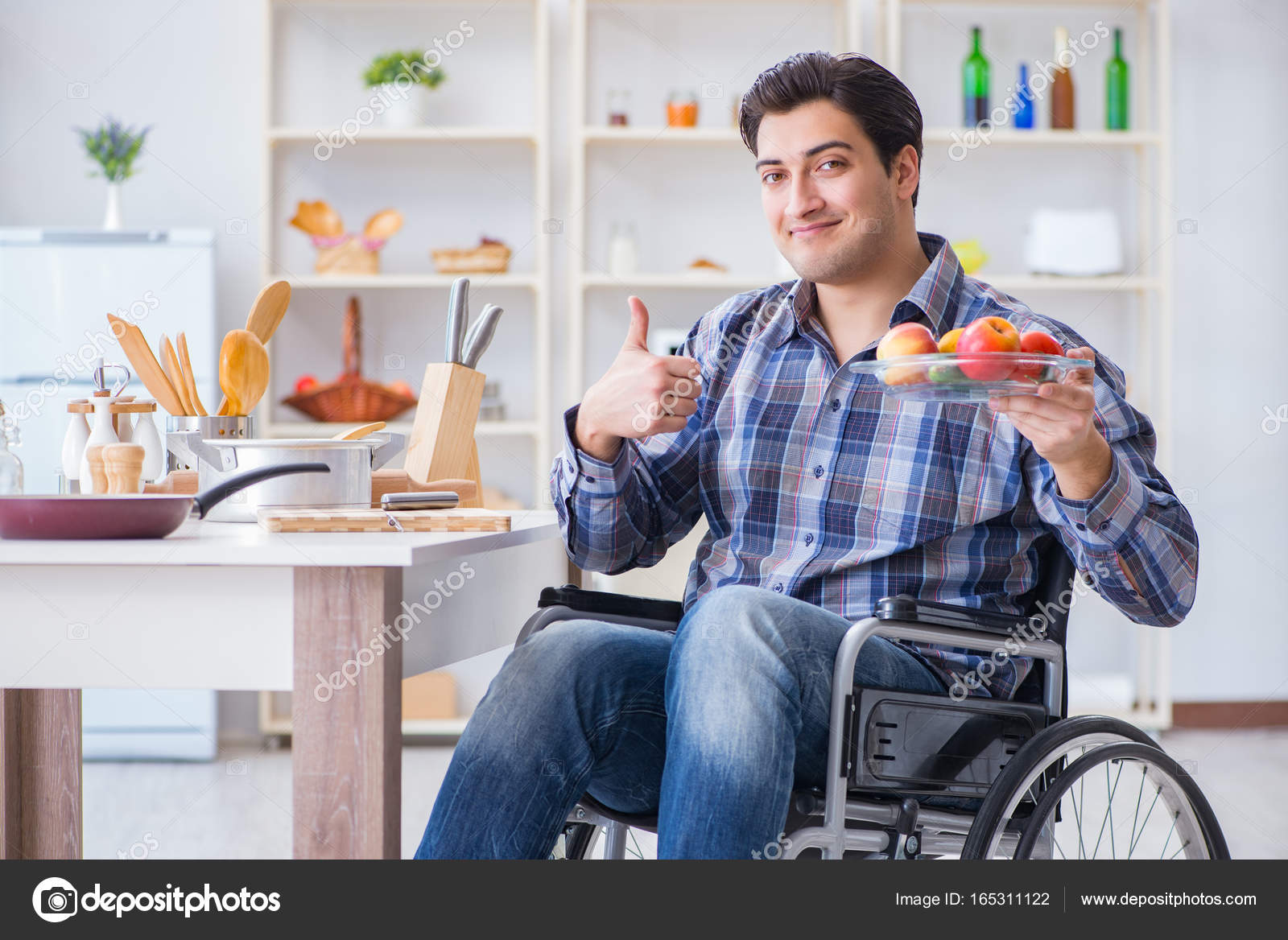 Young disabled husband preparing food salad Stock Photo by ©Elnur
