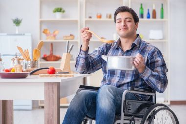Engelli adam mutfakta çorba hazırlıyor.