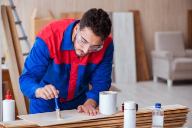 Yooung marangoz boyayla uğraşıyor.