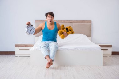 Genç adam yatakta uyanıyor.