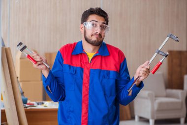 Klemplerle çalışan genç bir tamirci.