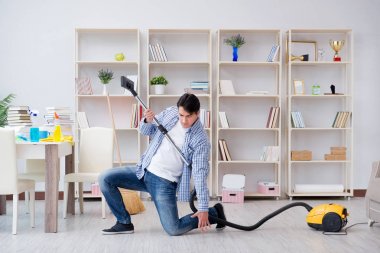 Adam evi temizliyor.