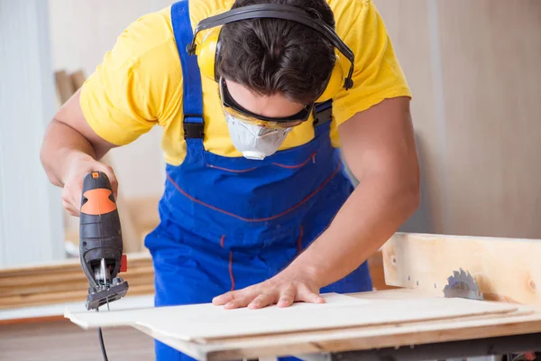Молодий ремонтник столяр, що працює з циркулярною пилкою — стокове фото