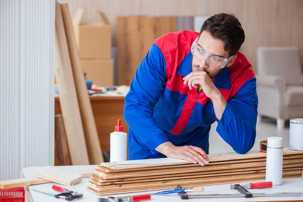 Yooung marangoz boyayla uğraşıyor.