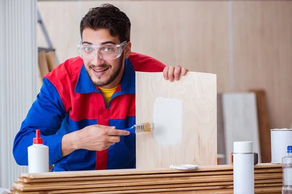 Yooung marangoz boyayla uğraşıyor.