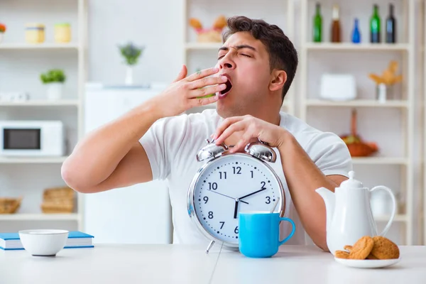 Hombre con despertador durmiendo en el desayuno —  Fotos de Stock