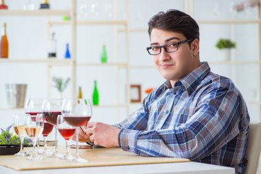 Profesyonel şarap garsonu kırmızı şarap tadıyor.
