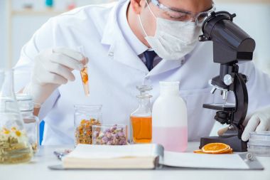 Laboratuvarda parfüm karıştıran bir kimyager.