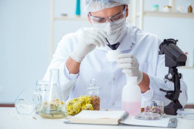 Laboratuvarda parfüm karıştıran bir kimyager.