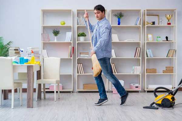 Adam evi temizliyor.