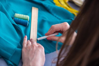 Kadın terzi dikiş dikmek için dikiş dikiyor.