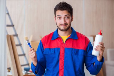 Yooung marangoz boyayla uğraşıyor.