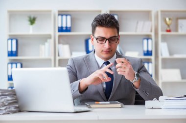 İşadamı ofisinde sigara içiyor.