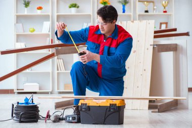 Genç marangoz ahşap kalaslarla çalışıyor.