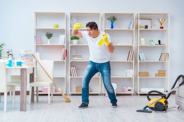 Adam evi temizliyor.